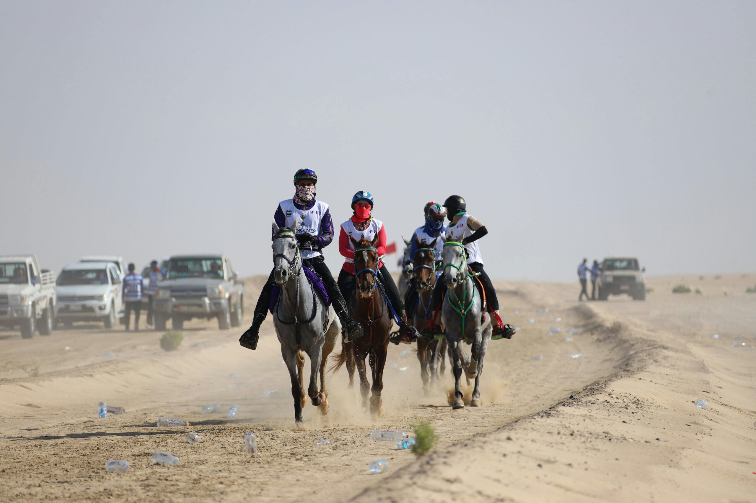 Horse riders compete in a desert endurance race, showcasing determination and skill.